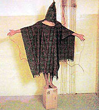 Human on box with electrodes attached to genitals ++ We Don't Torture - George Bush