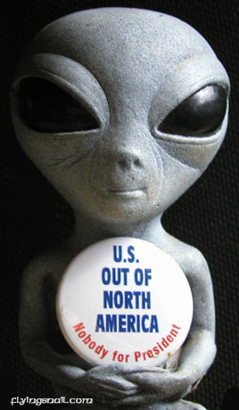 Alien holding button saying, "U.S. OUT OF NORTH AMERICA - NOBODY FOR PRESIDENT