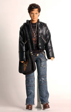 Ken sports a motorcycle jacket, torn jeans, and untidy hair (sigh)