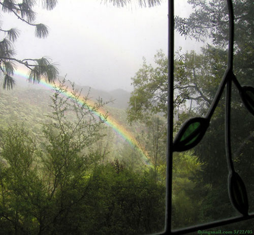 Rainbow in canyon behind house.